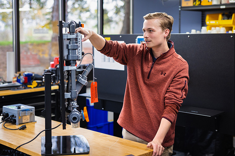 Brenden, a freshwater sciences major working with lab equipment at his internship.